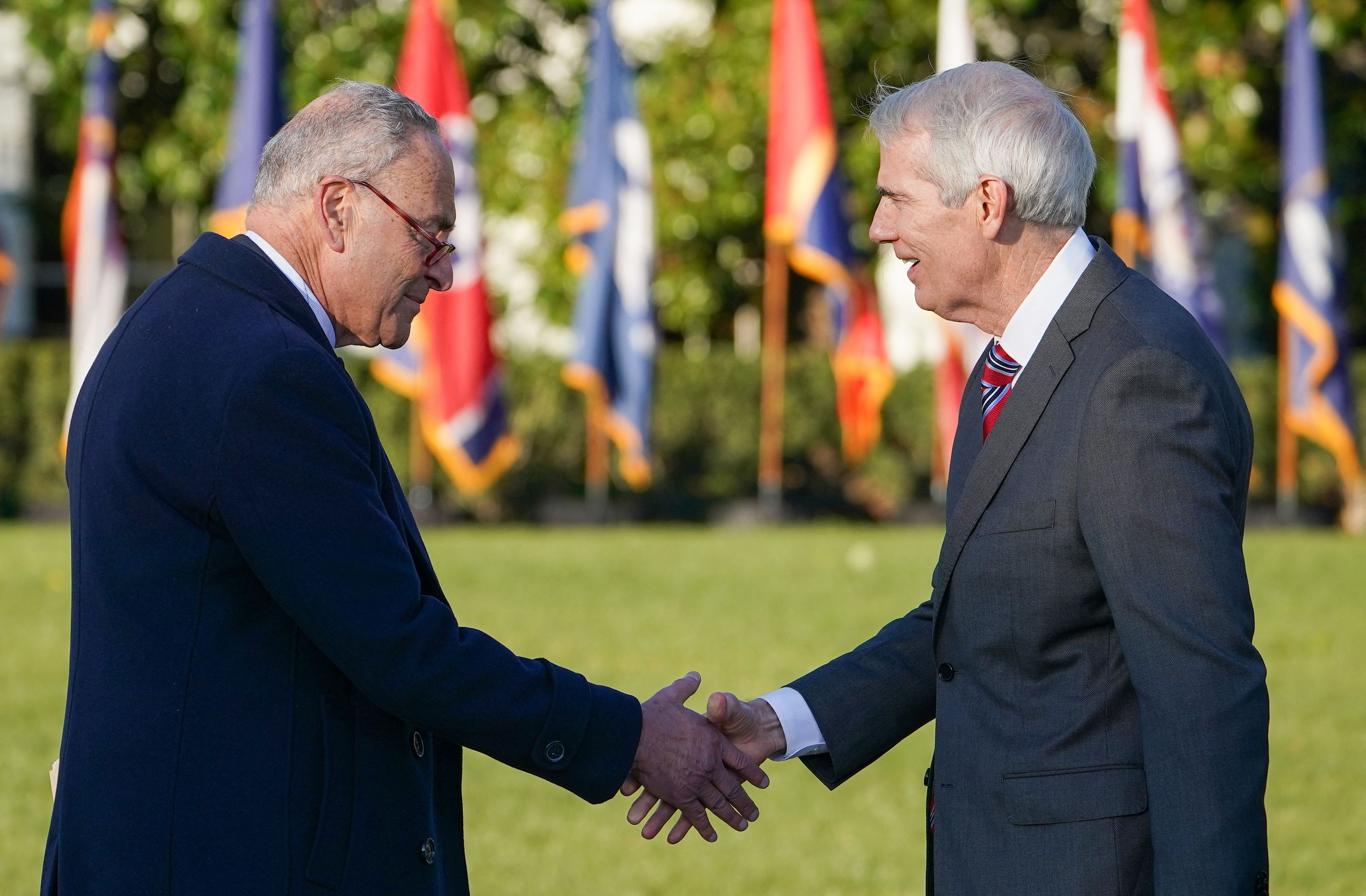 Sen. Rob Portman is seen shaking hands with Senate Majority Leader Chuck Schumer at the ceremony to sign the bipartisan infrastructure bill.