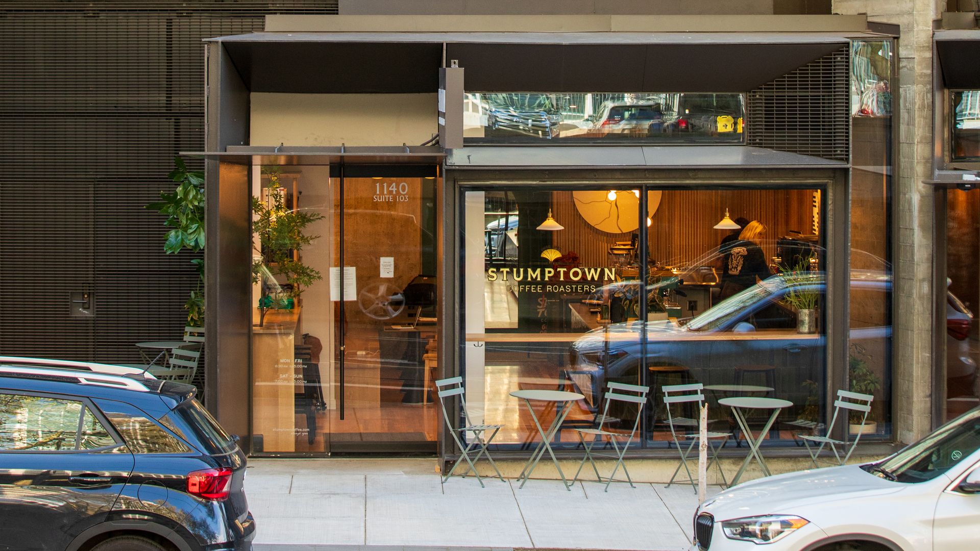 A photo of a building with chairs in front and a sign that reads "Stumptown Coffee"