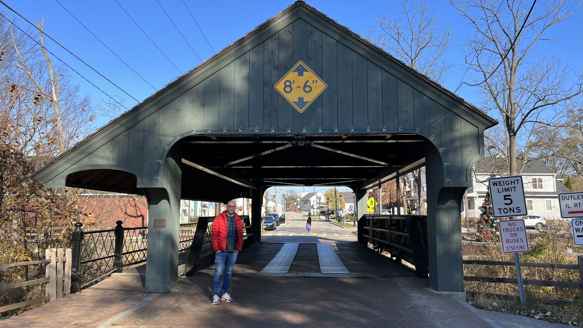 Photo of a man standing in front of a bridge