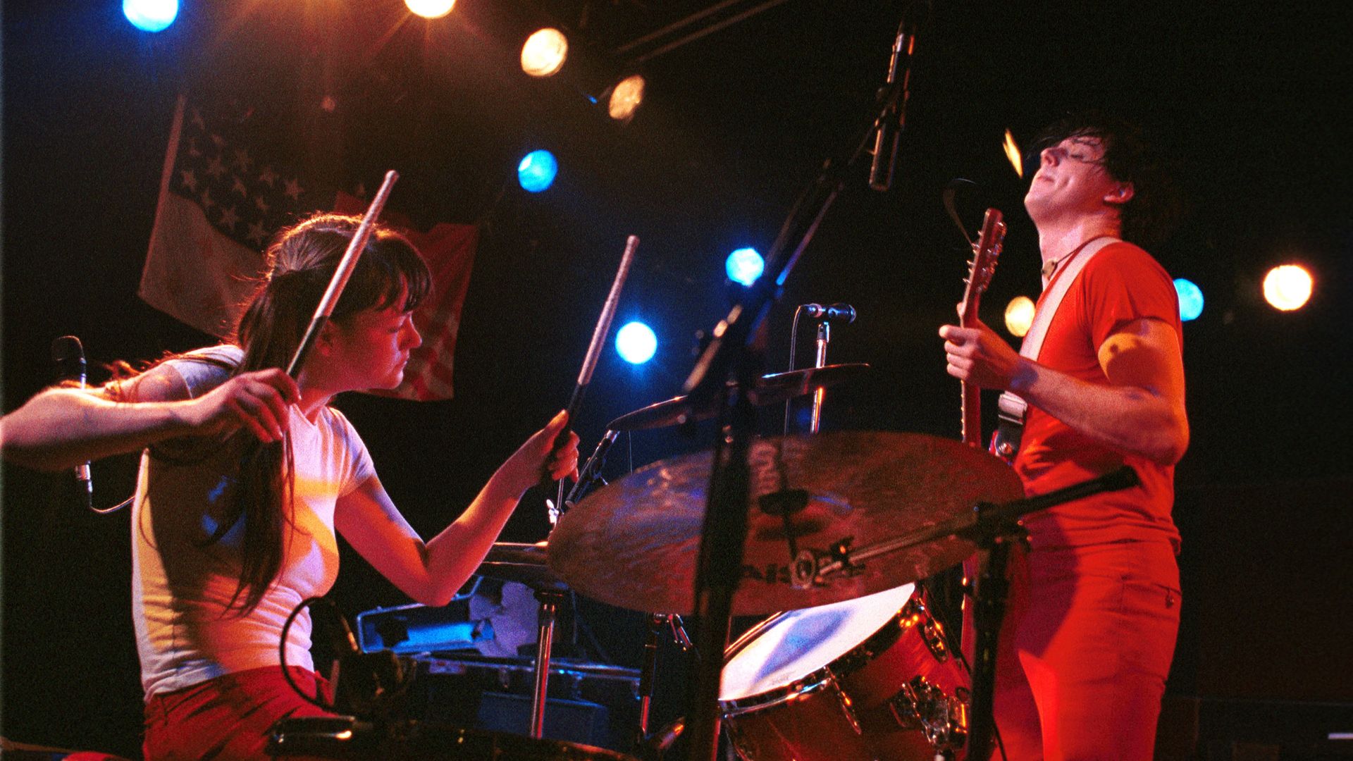 Meg White plays the drums and Jack White stands to the left of her on guitar of the White Stripes.