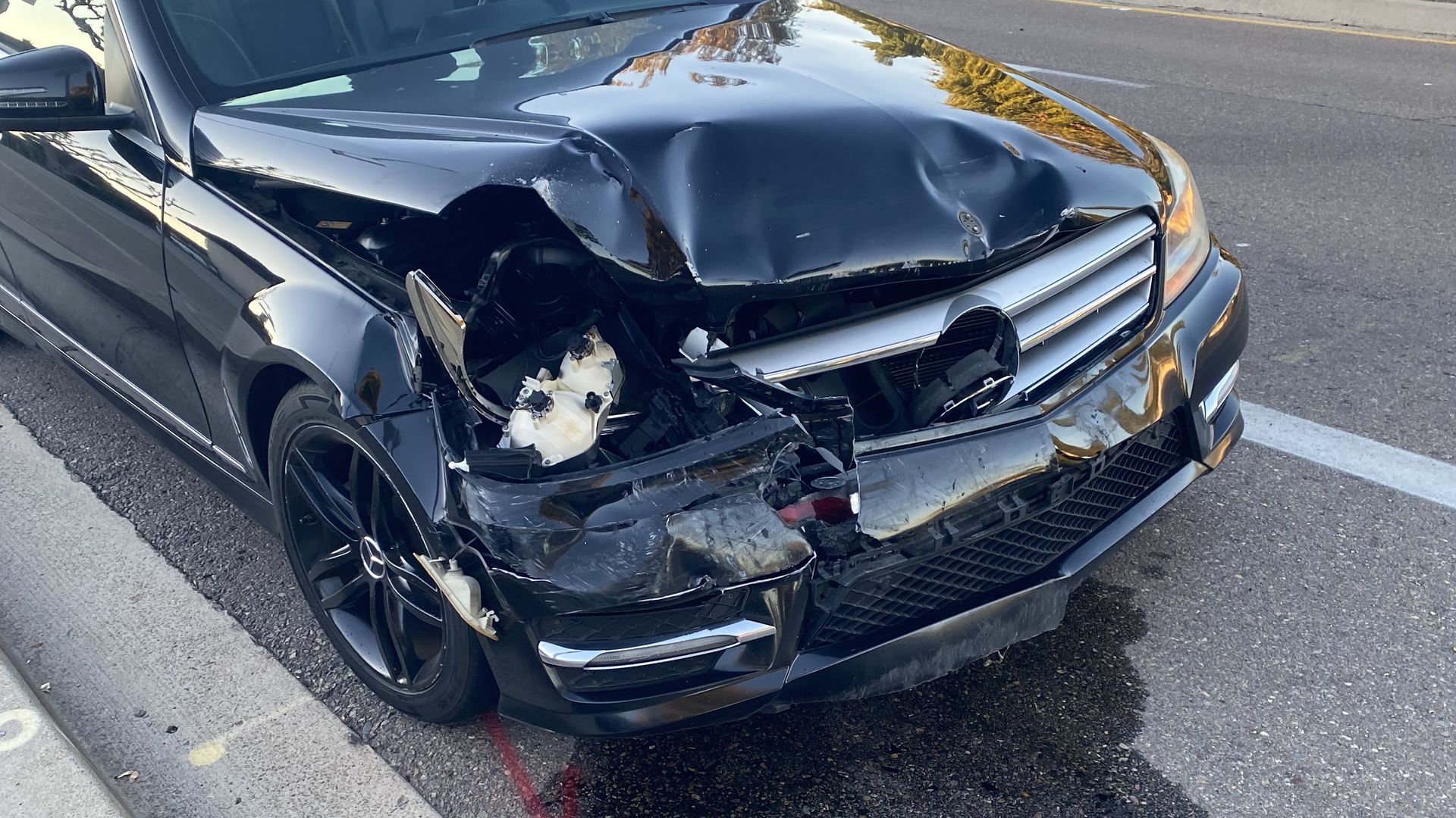 A damaged car on the side of the road.
