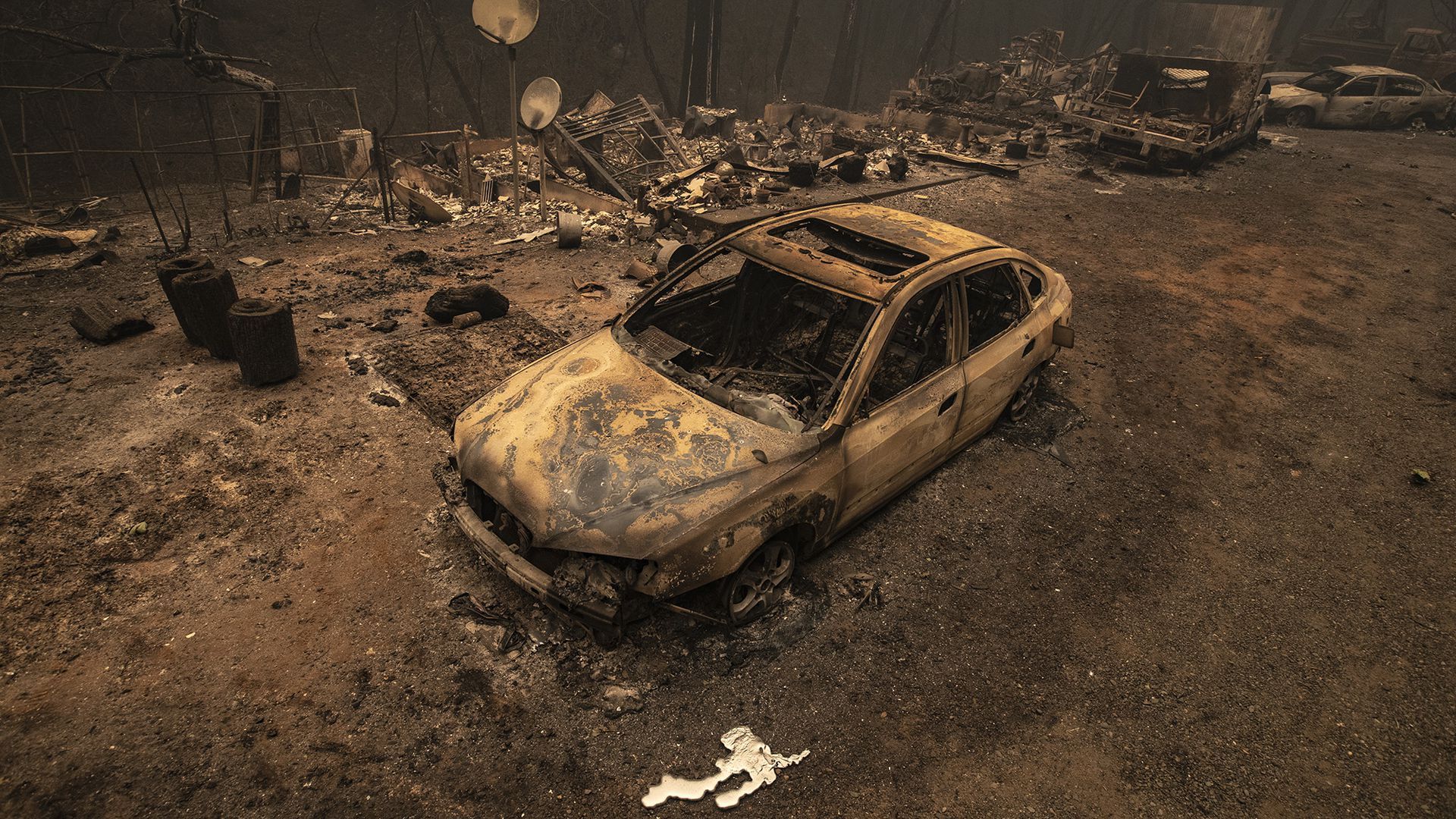 A burned vehicle sits in front of a home destroyed in the North Complex fire in Berry Creek, California. 