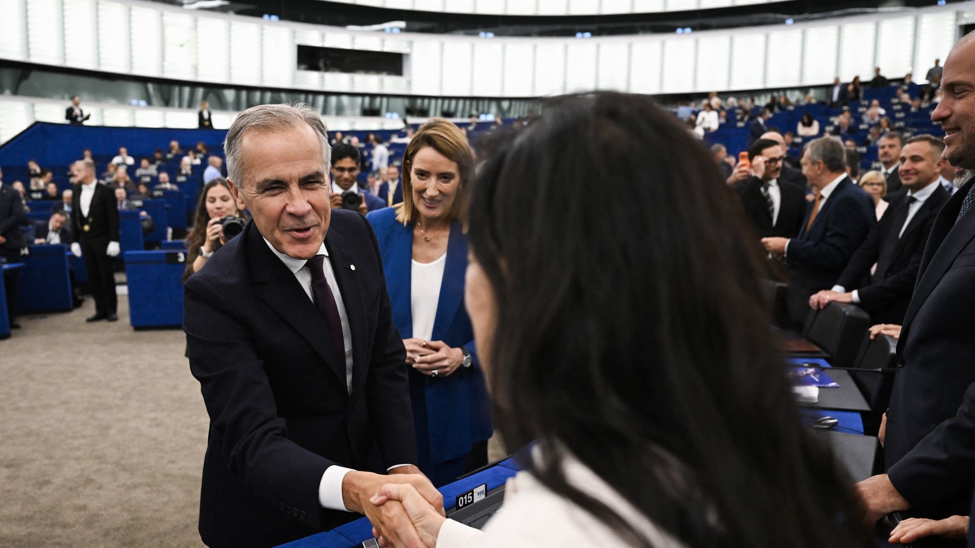 Canadian Prime Minister Mark Carney greets a member of the European Parliament as European Parliament President Roberta Metsola stands behind him in Strasbourg, France.