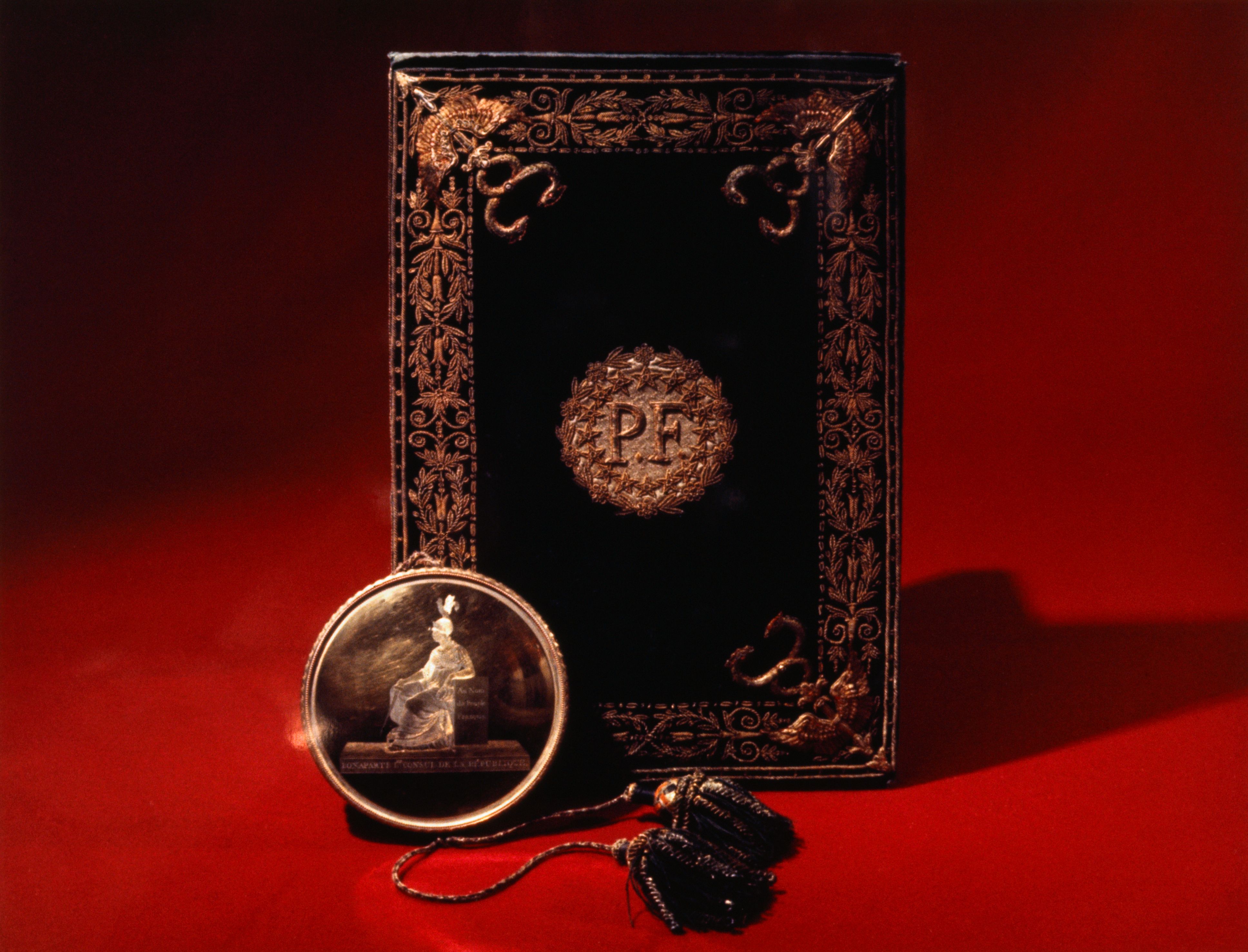 Image shows an ornate book on a red background.