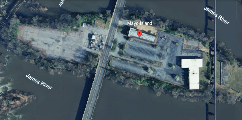 a satellite view of a concrete and parking lot island two three small buildings on it