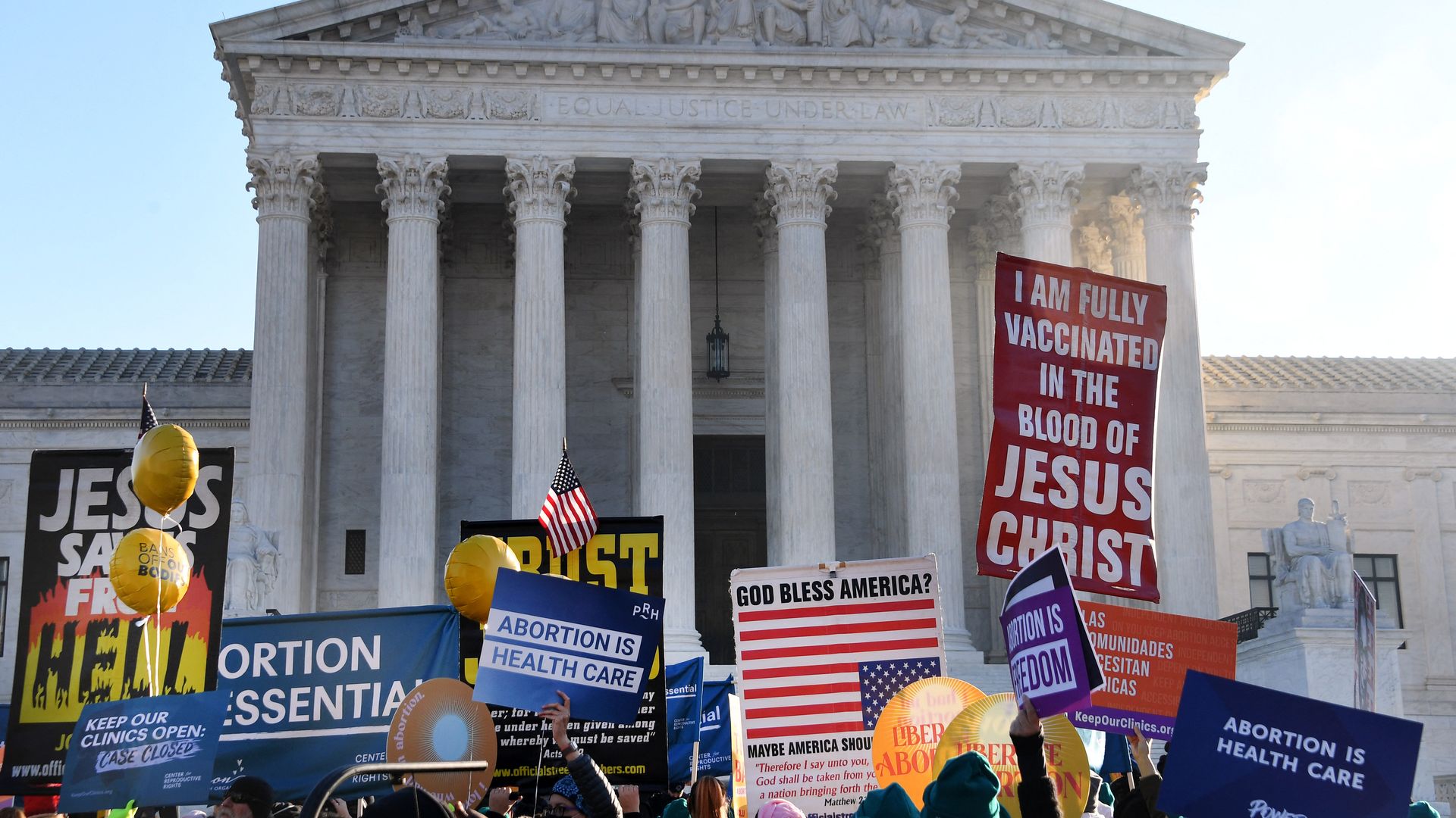 Picture of the Supreme Court building with people holding signs in front of it in support and against abortion.
