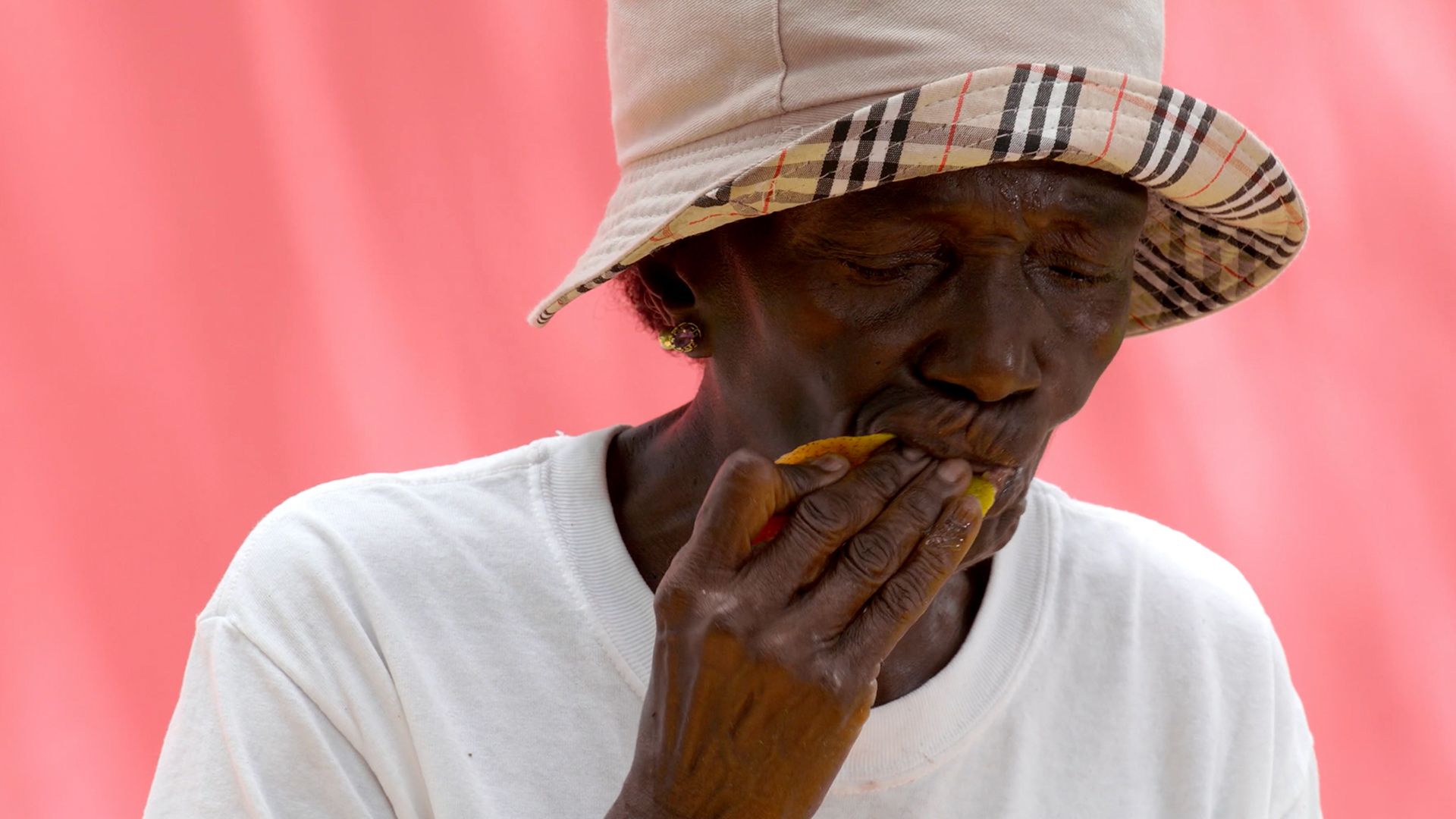 A woman eats a mango