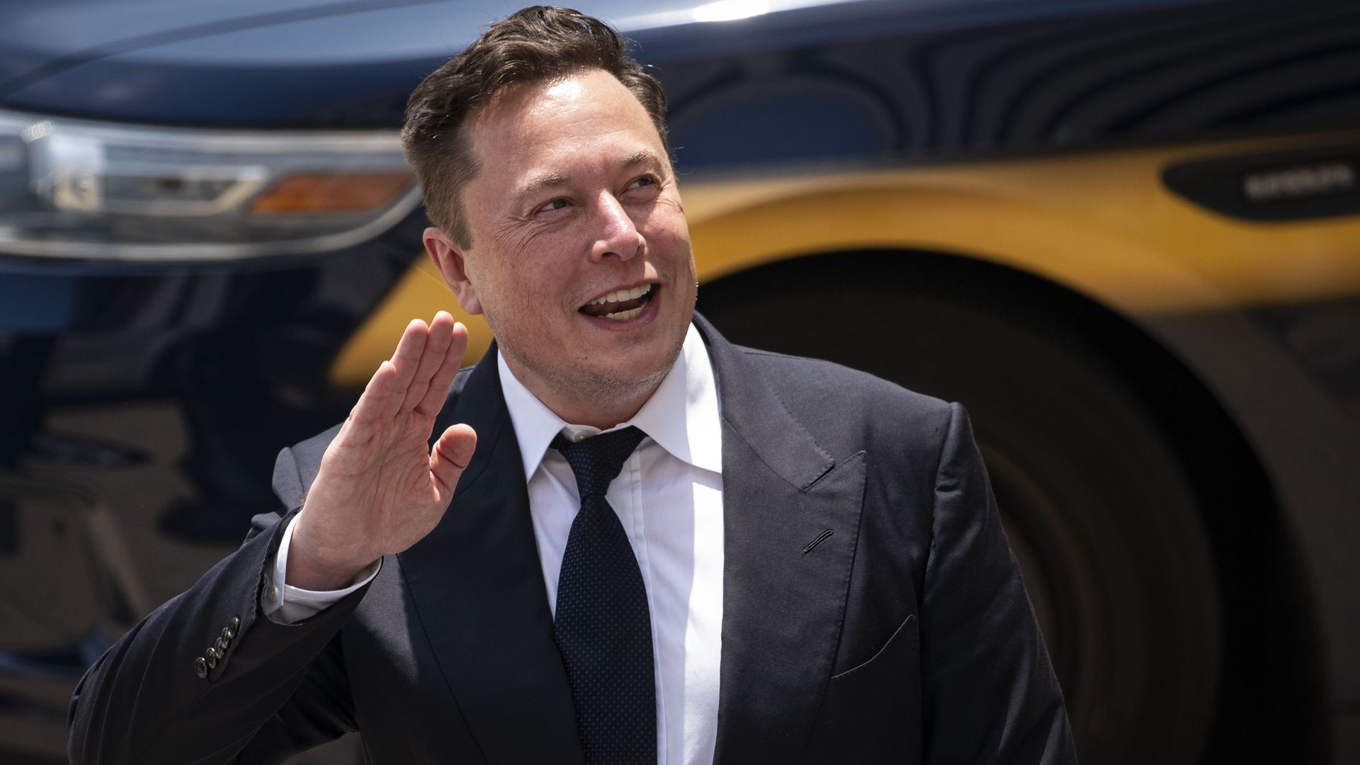 Elon Musk, chief executive officer of Tesla Inc., waves while departing court during the SolarCity trial in Wilmington, Delaware, U.S.