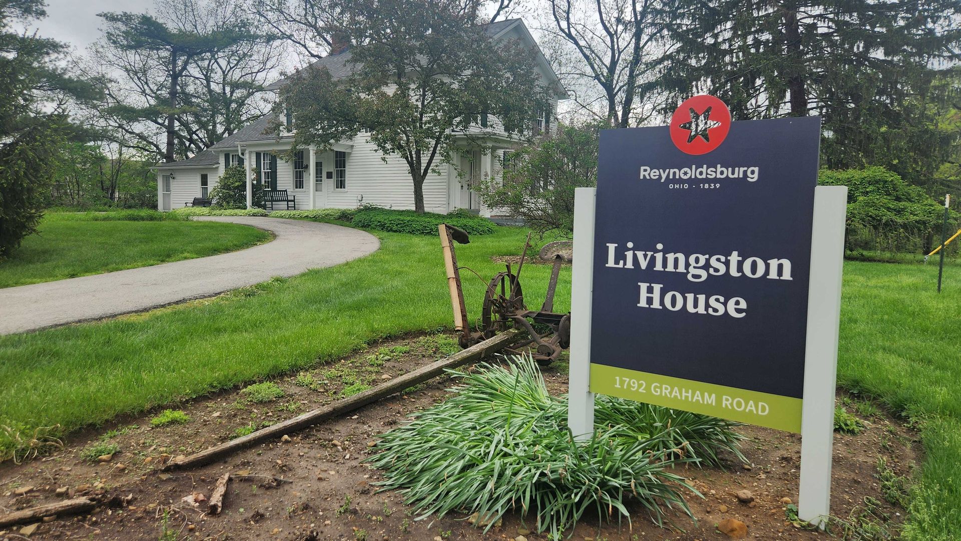 A sign for the Livingston House in front of the two-story house. 