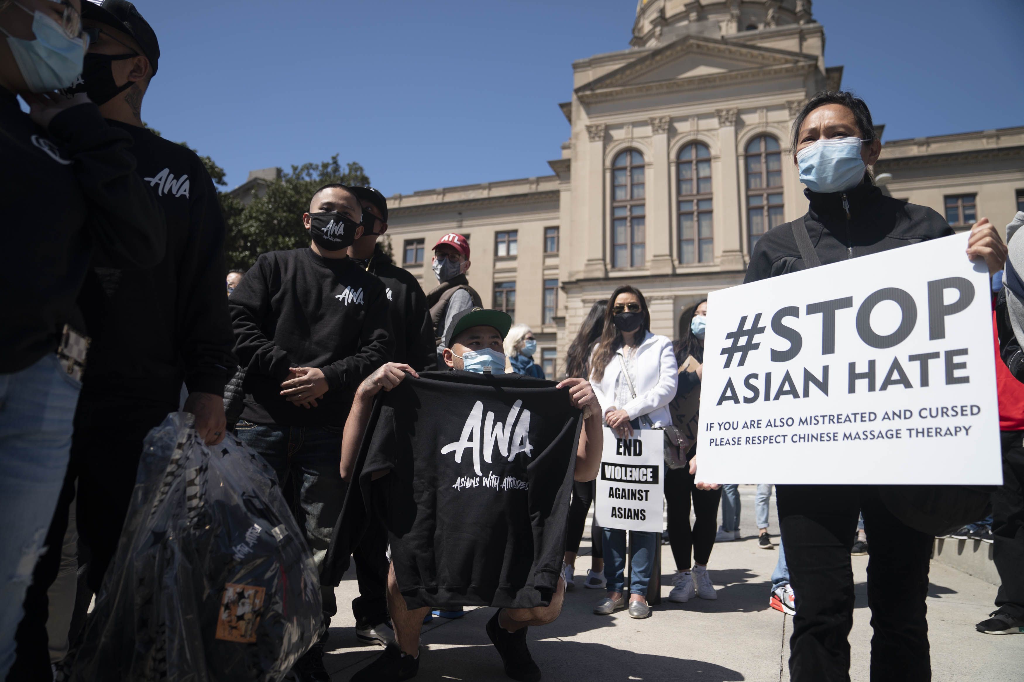 Demonstrators hold signs during a Stop AAPI Hate Rally outside the State Capitol building in Atlanta, Georgia, U.S., on Saturday, March 20